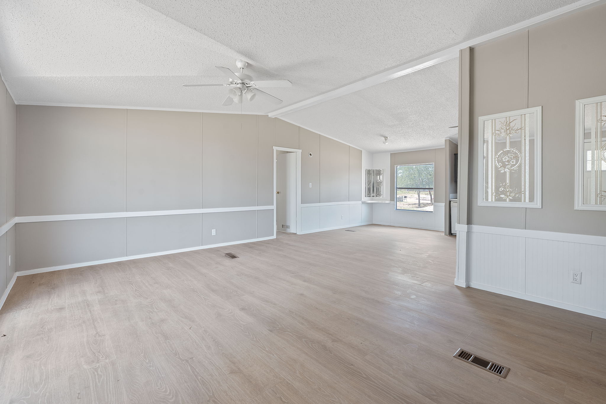 1385 Pettytown Road Dale, TX 78616 - Photo 5 of 27 Unfurnished room with a decorative wall, light wood-style flooring, a textured ceiling, a ceiling fan, and lofted ceiling
