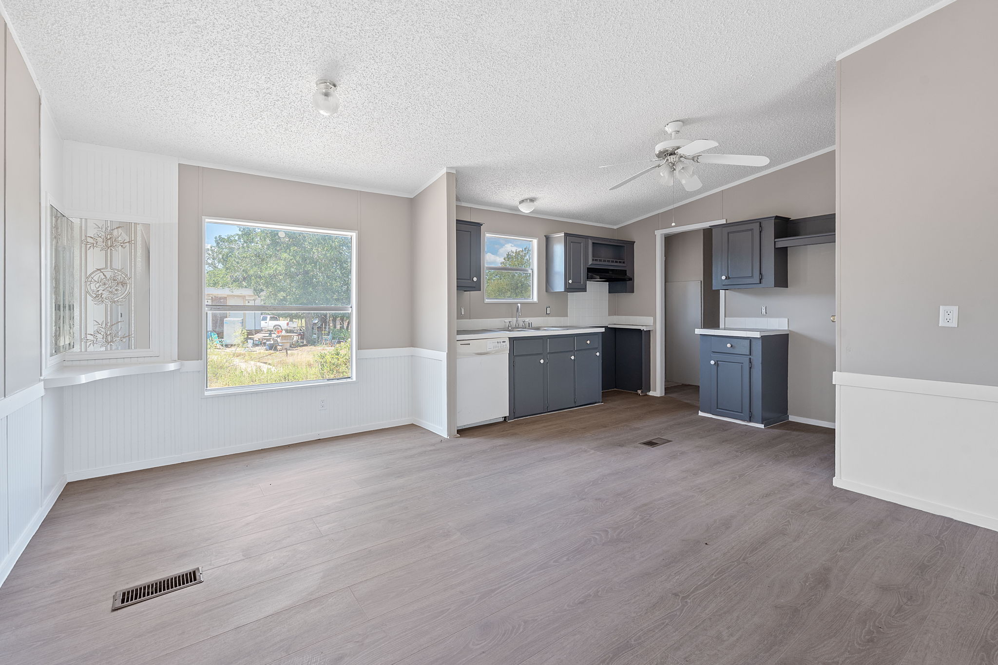 1385 Pettytown Road Dale, TX 78616 - Photo 6 of 27 Kitchen with light countertops, light wood finished floors, crown molding, dishwasher, and a ceiling fan