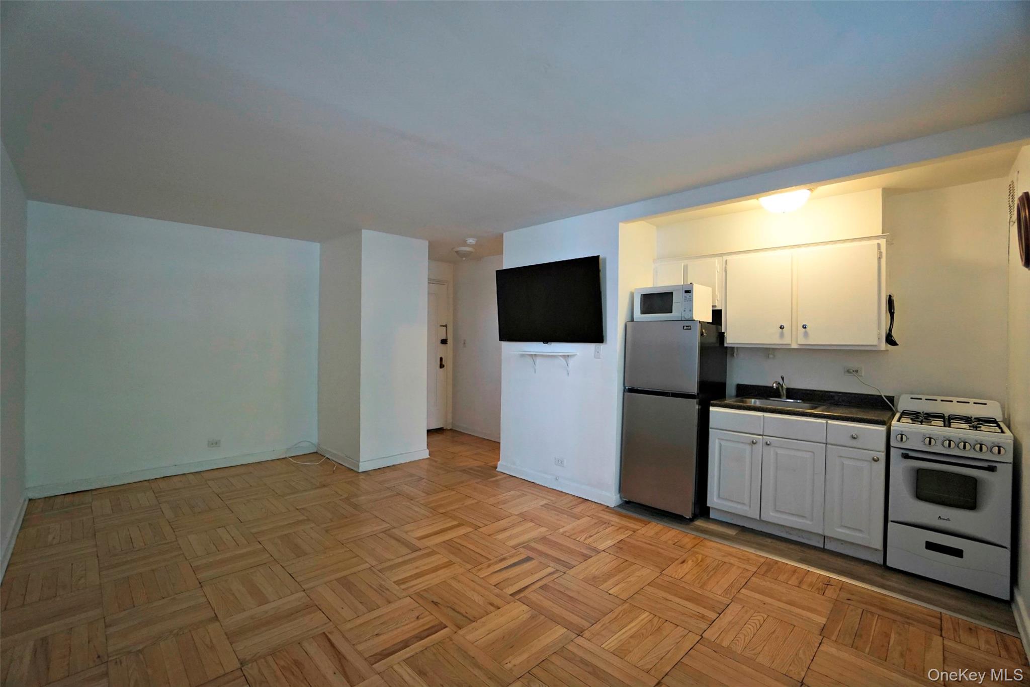7281 113th Street, Unit 2B Queens, NY 11375 - Photo 3 of 18 a kitchen with a refrigerator and a stove top oven