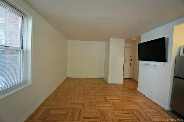 a view of a livingroom with an empty space & a flat screen tv
