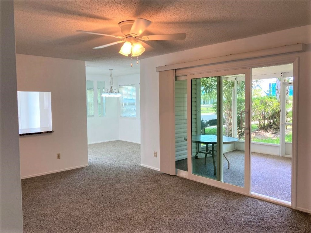 a view of an empty room with glass door and balcony