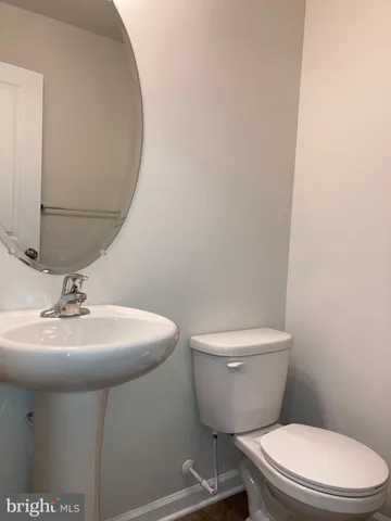 a bathroom with a toilet a sink and mirror