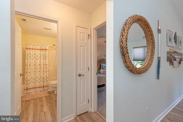 a bedroom with a bed a dresser and wooden floor