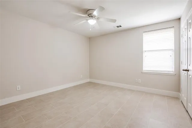 an empty room with a window and a fan