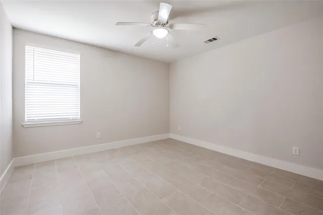 an empty room with a window and a fan