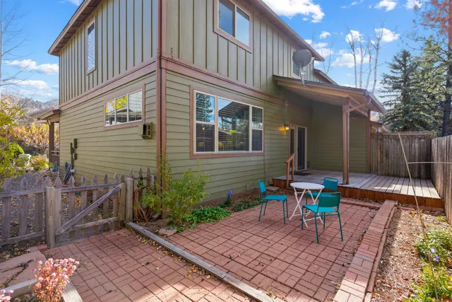 a view of backyard with table and chairs and wooden fence