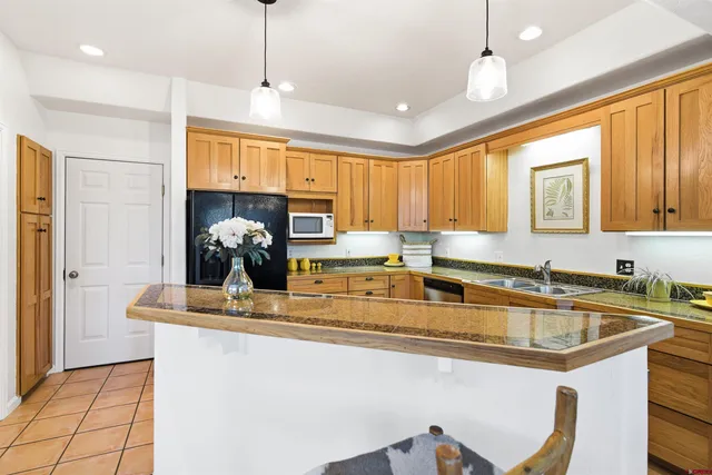 a kitchen with stainless steel appliances granite countertop a sink a stove and a refrigerator