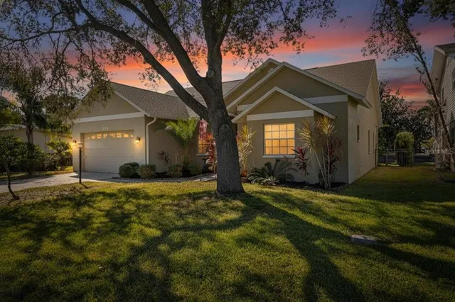 a view of a house next to a yard with potted plants