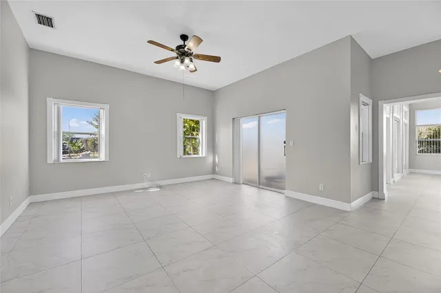 an empty room with a window and a ceiling fan