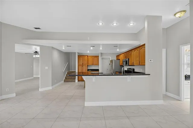 a kitchen with granite countertop a refrigerator and a stove top oven