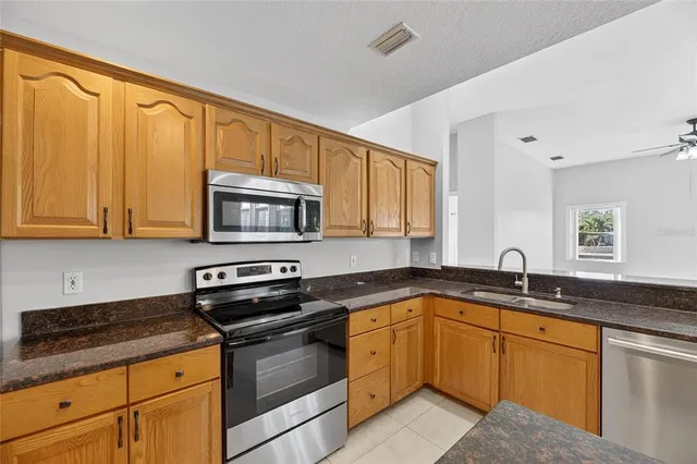 an empty room with a chandelier fan and windows