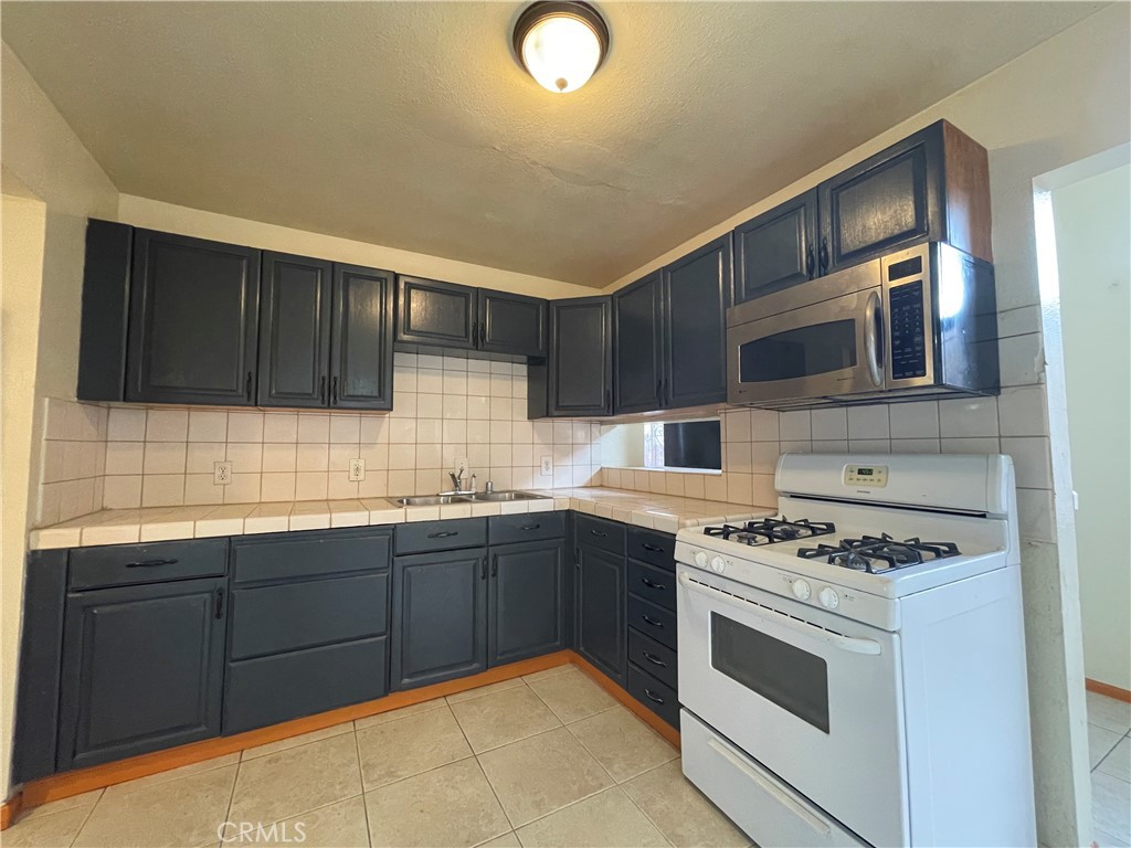 1349 Walnut Avenue Long Beach, CA 90813 - Photo 3 of 13 a kitchen with stainless steel appliances granite countertop a stove and a sink