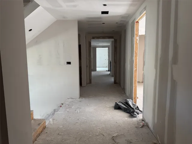 a view of a hallway with staircase and door