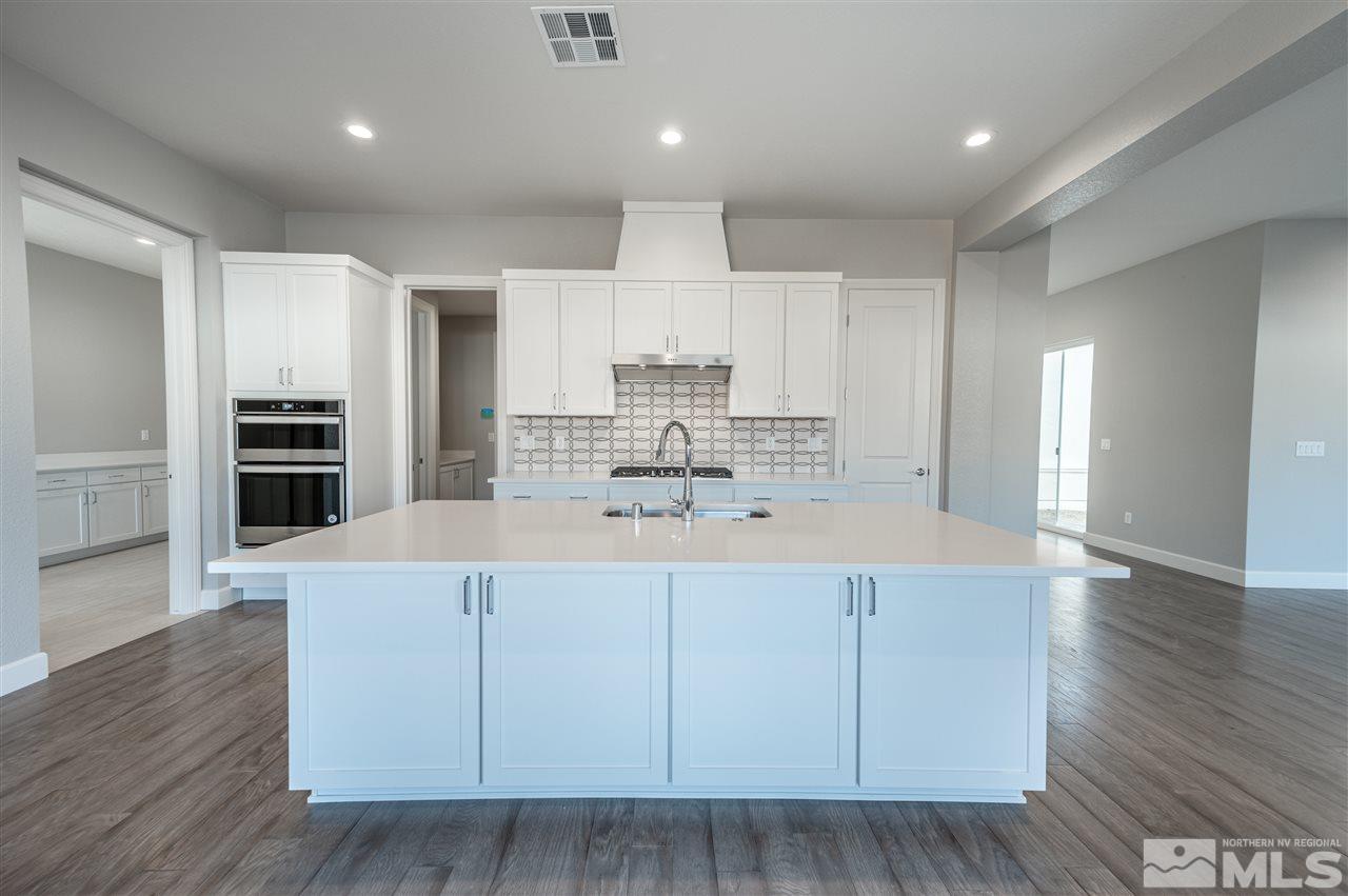 9326 Mayfair Way, Unit HOMESITE 66 Reno, NV 89521 - Photo 5 of 30 a large kitchen with kitchen island a sink stainless steel appliances and cabinets