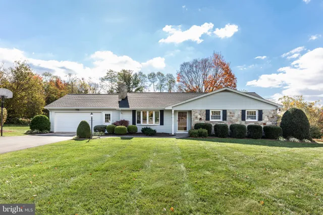 a view of a house with a big yard and large trees