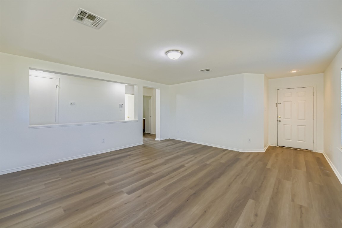 101 Bandara Woods Boulevard Elgin, TX 78621 - Photo 4 of 11 a view of an empty room with wooden floor and a window