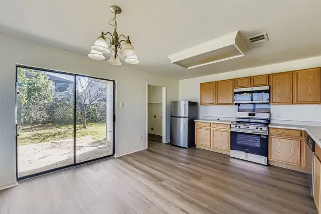 a kitchen with stainless steel appliances granite countertop a stove and cabinets