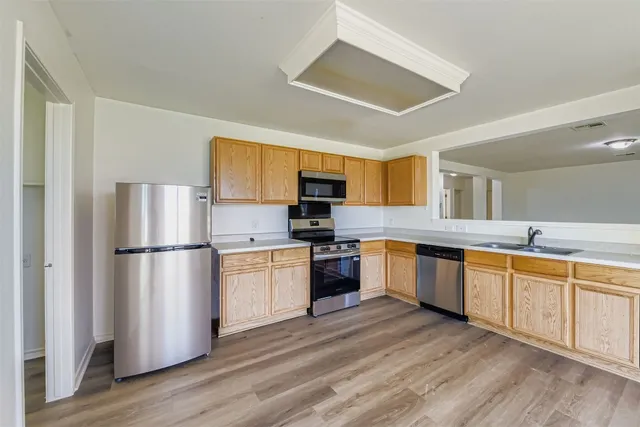 a kitchen with granite countertop stainless steel appliances a refrigerator a microwave a sink and cabinets