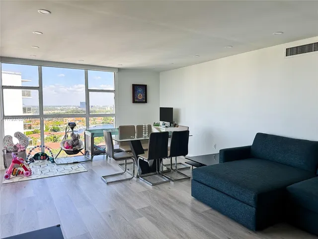 a living room with furniture and a floor to ceiling window