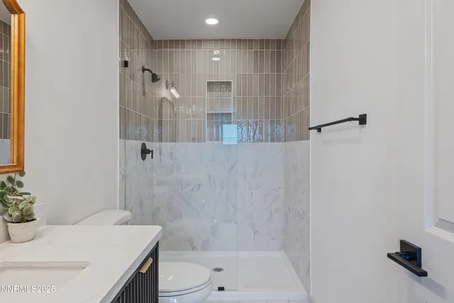 a bathroom with a sink a toilet and shower