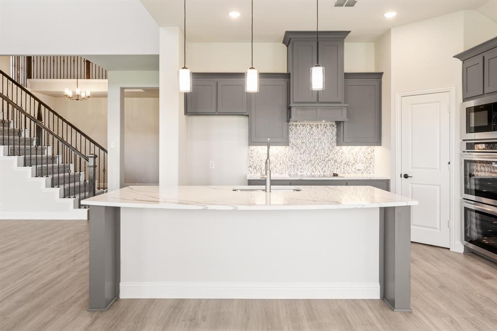 12605 Rocky Top Road Godley, TX 76044 - Photo 19 of 40 a view with stainless steel appliances kitchen island a chandelier and fireplace