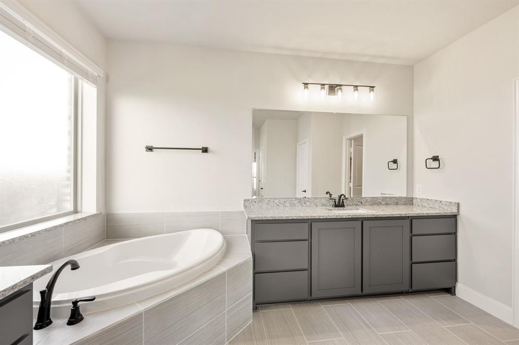 12605 Rocky Top Road Godley, TX 76044 - Photo 25 of 40 a bathroom with a tub sink and mirror