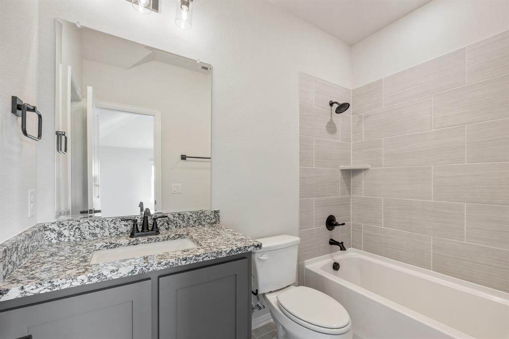 12605 Rocky Top Road Godley, TX 76044 - Photo 36 of 40 a bathroom with a granite countertop sink toilet and shower