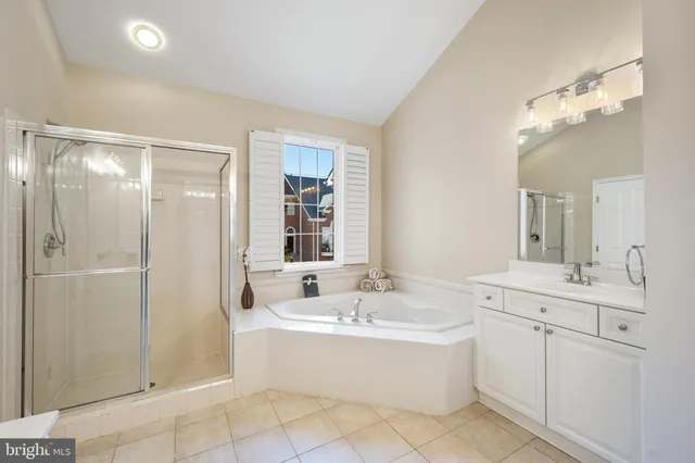 a large bathroom with a double vanity sink a mirror and a bathtub