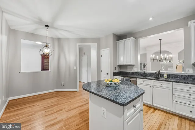 a kitchen with a stove a sink dishwasher a kitchen island with wooden cabinets and floor