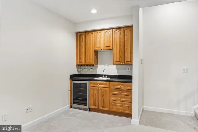 a backyard of a house with large trees and wooden fence