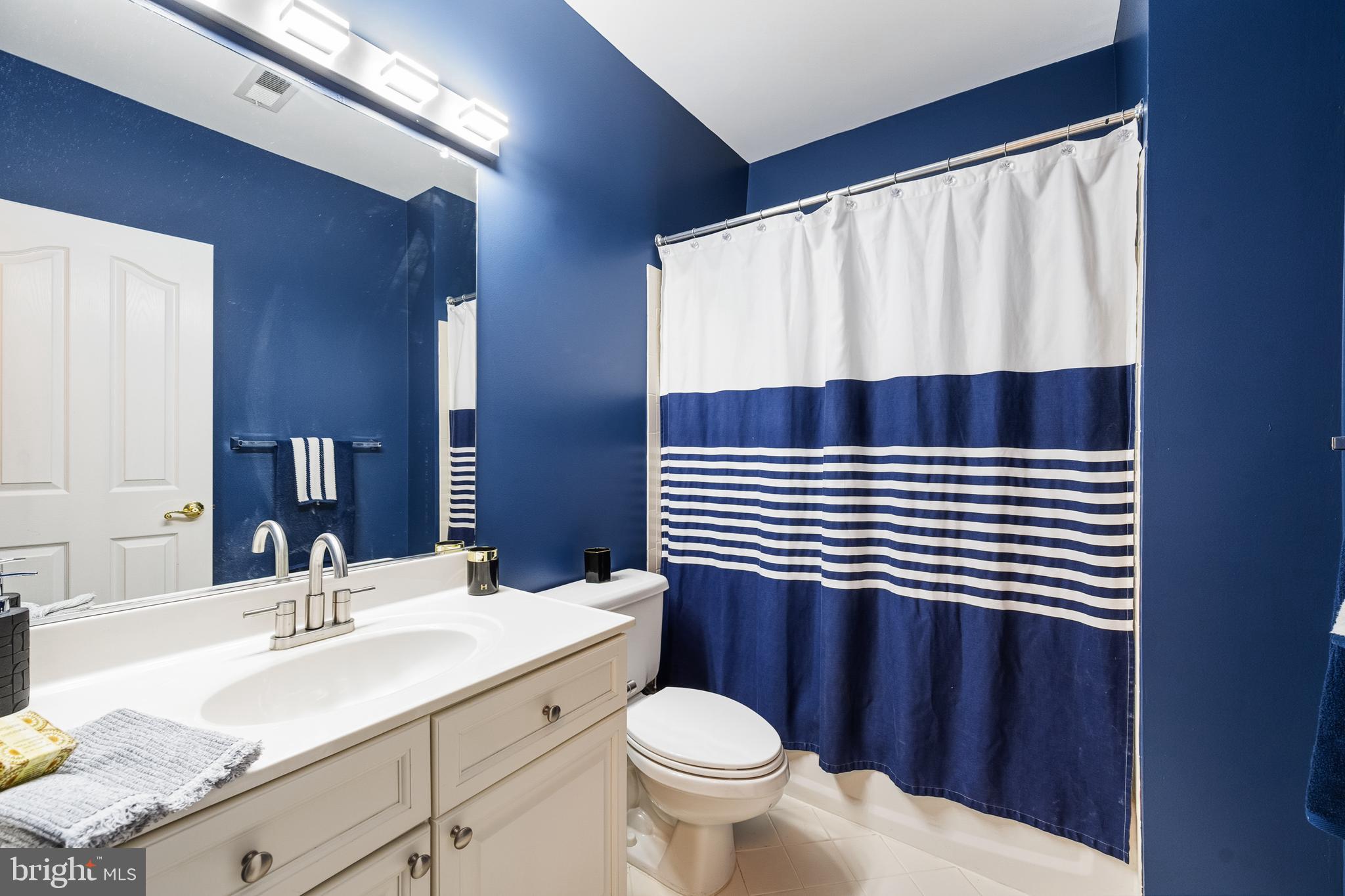 1919 Logan Manor Drive Reston, VA 20190 - Photo 37 of 57 a bathroom with a sink a toilet a mirror and shower curtain