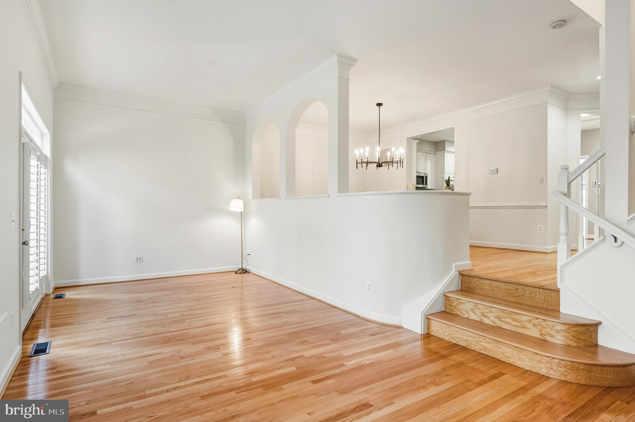 1919 Logan Manor Drive Reston, VA 20190 - Photo 8 of 57 a view of an empty room with wooden floor and a kitchen view