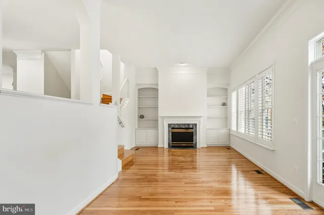 a view of empty room with wooden floor and fireplace