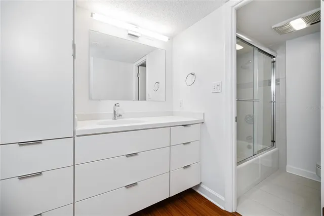 a bathroom with a shower sink and mirror