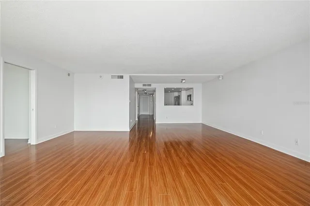 a view of empty room with wooden floor