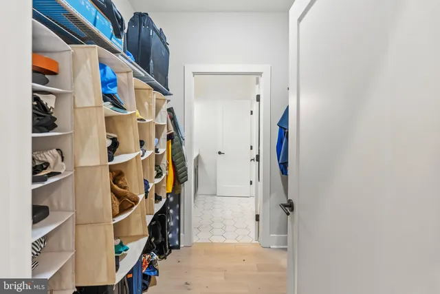 a view of walk in closet with clothes and shoes