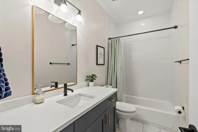 a bathroom with a sink a toilet and shower a mirror