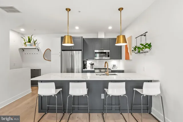 a kitchen with granite countertop a table chairs stove and a wooden floor