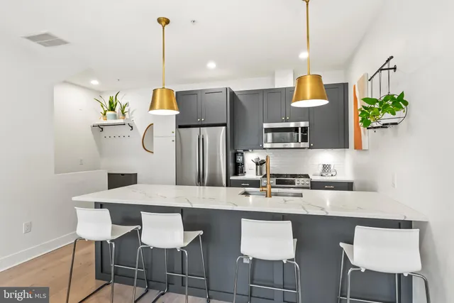 a kitchen with kitchen island granite countertop a table and chairs in it