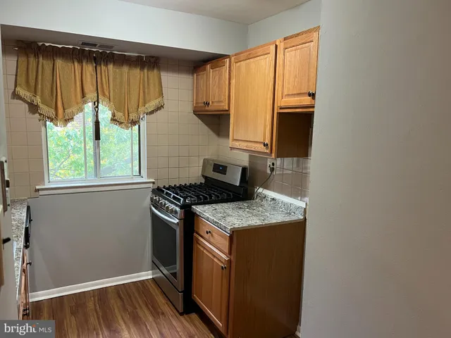 a kitchen with a stove a sink and a window