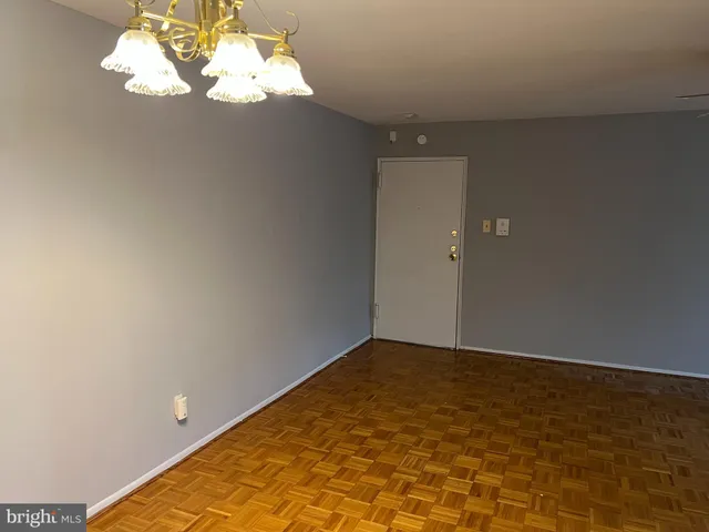 a view of an empty room with a chandelier fan