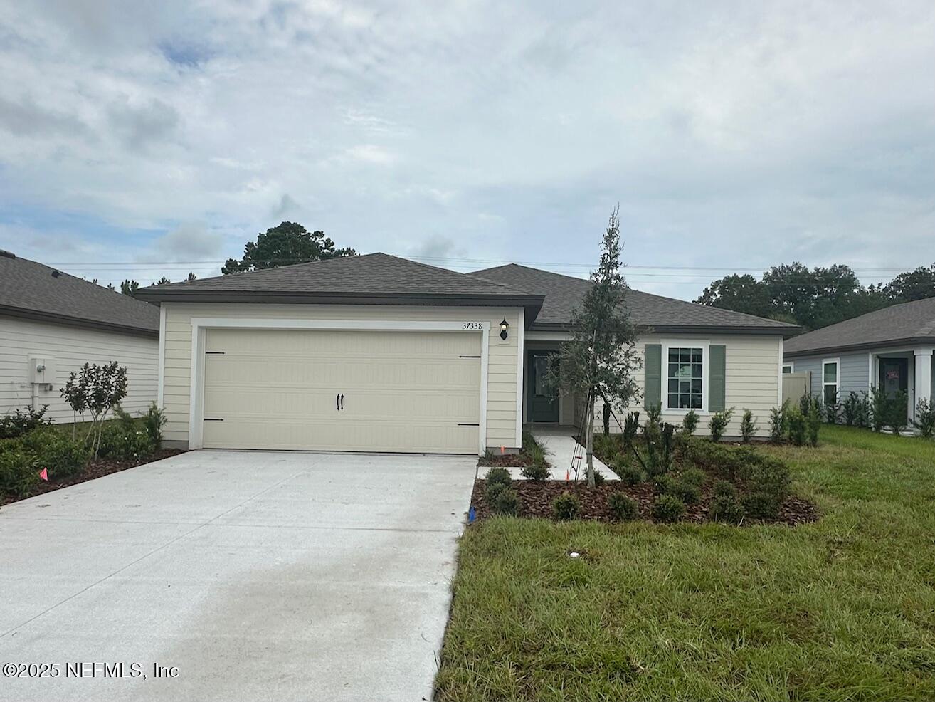 37338 Whisper Way Hilliard, FL 32046 - Photo 1 of 14 a front view of a house with garden