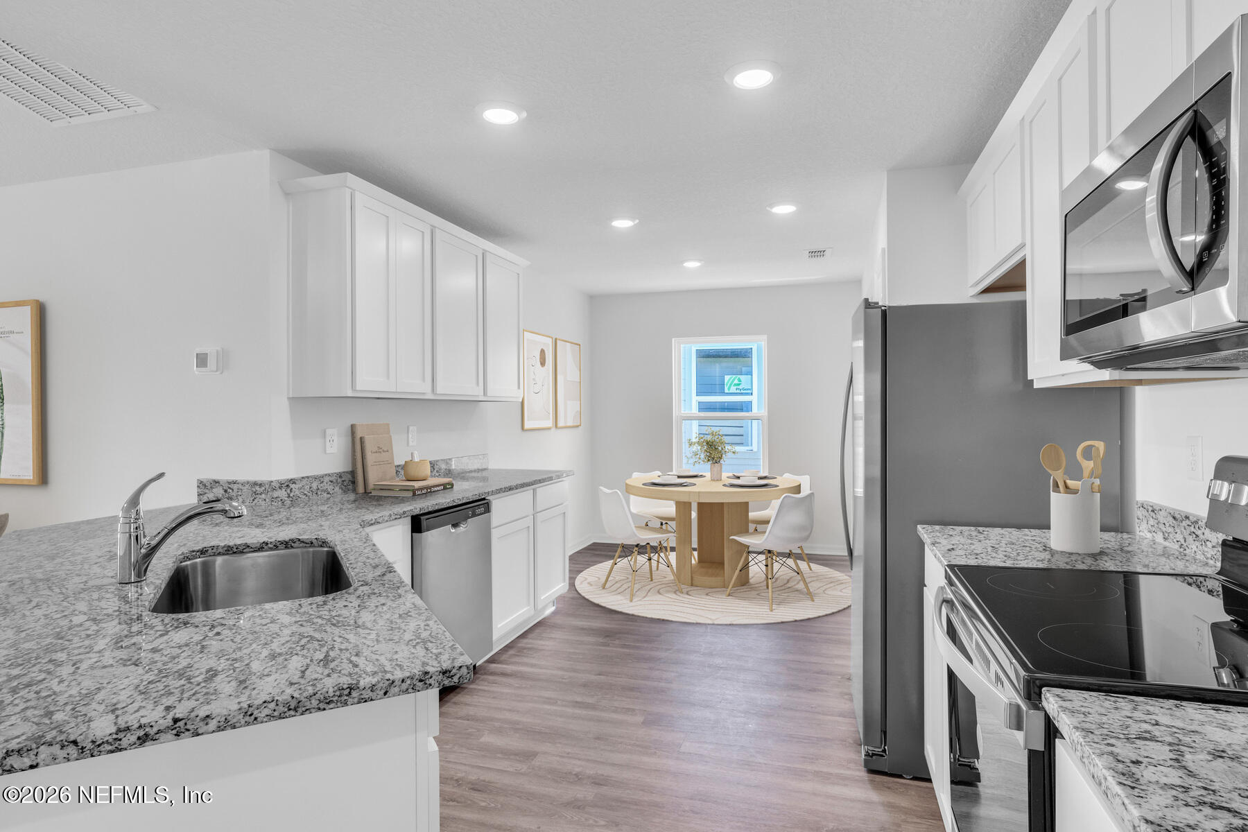 37338 Whisper Way Hilliard, FL 32046 - Photo 3 of 14 a kitchen with stainless steel appliances granite countertop a sink dishwasher a stove and a refrigerator with wooden floor