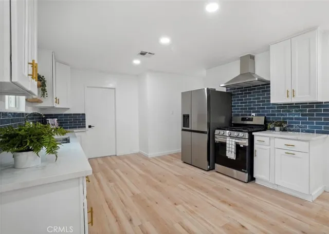 a kitchen with stainless steel appliances a sink dishwasher stove refrigerator and microwave