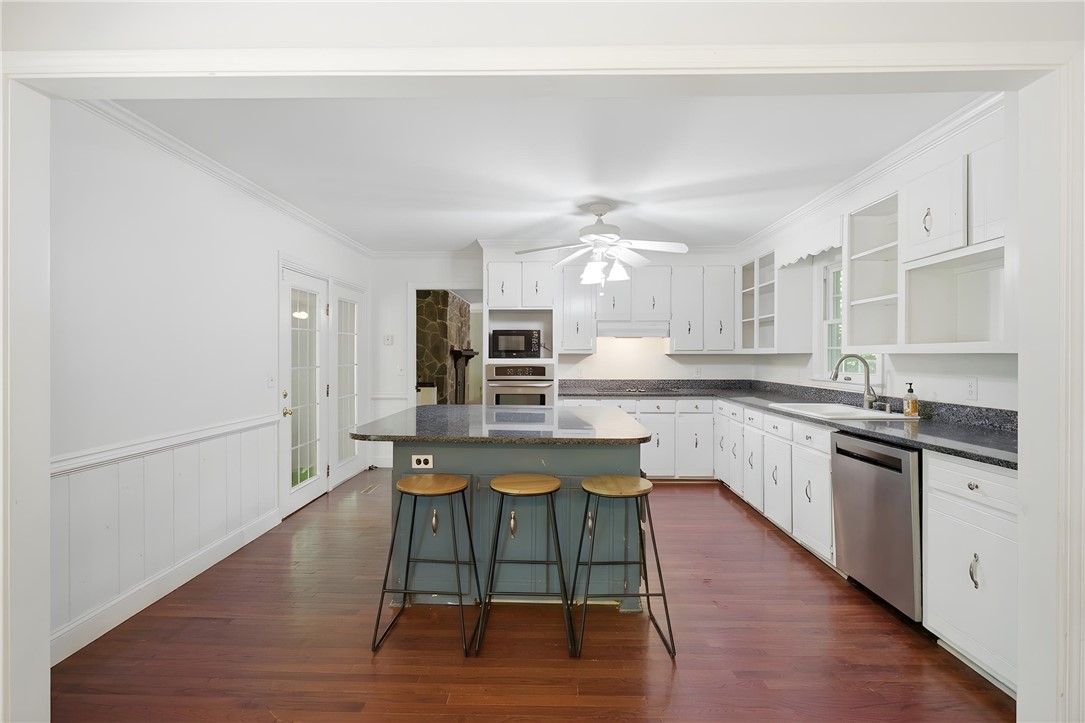 311 Cumberland Way Anderson, SC 29621 - Photo 12 of 44 A well-lit kitchen with rich hardwood floors and a spacious island for gathering.