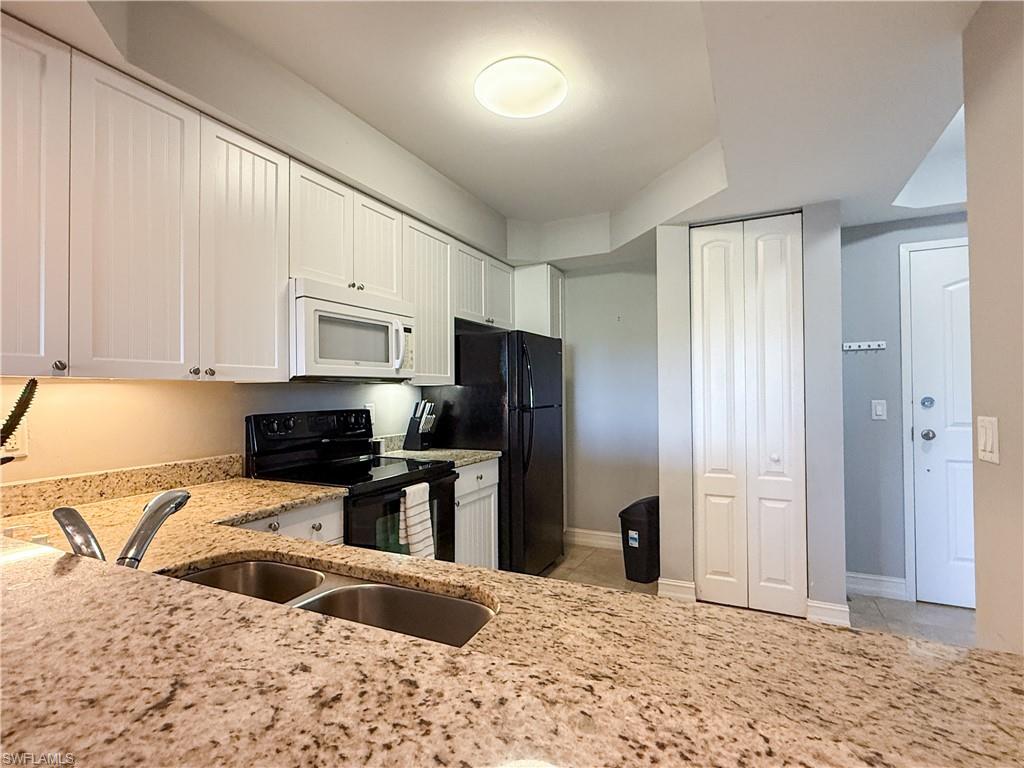 1100 Pine Ridge Road, Unit B405 Naples, FL 34108 - Photo 15 of 43 a kitchen with stainless steel appliances granite countertop a refrigerator a stove a sink and a granite counter tops