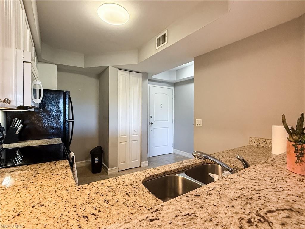 1100 Pine Ridge Road, Unit B405 Naples, FL 34108 - Photo 16 of 43 a kitchen with a stove refrigerator and sink