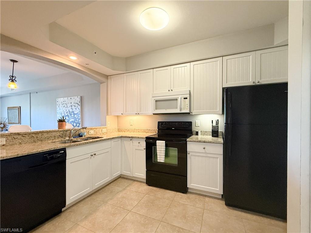 1100 Pine Ridge Road, Unit B405 Naples, FL 34108 - Photo 18 of 43 a kitchen with stainless steel appliances granite countertop a refrigerator and a stove top oven
