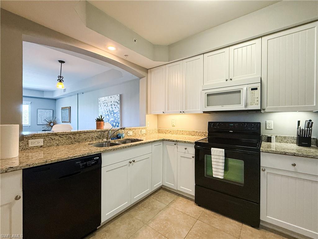 1100 Pine Ridge Road, Unit B405 Naples, FL 34108 - Photo 19 of 43 a kitchen with granite countertop cabinets stainless steel appliances and a sink