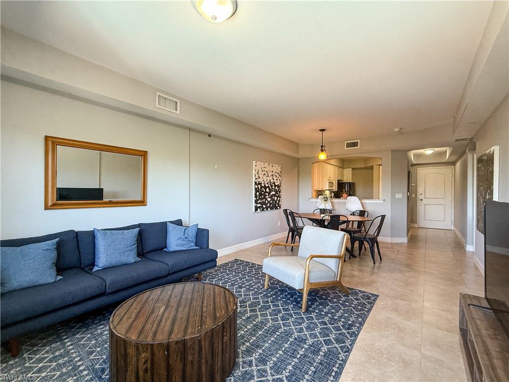 1100 Pine Ridge Road, Unit B405 Naples, FL 34108 - Photo 23 of 43 a living room with furniture and a table